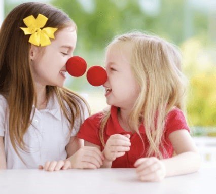 Two girls wearing red noses