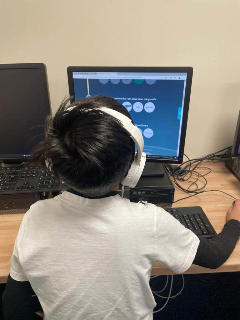 Child at desk doing online maths lesson